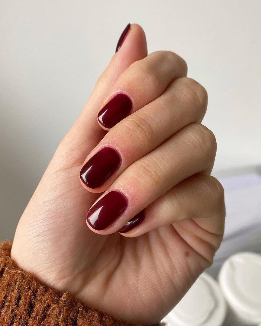 Dark red polish nails