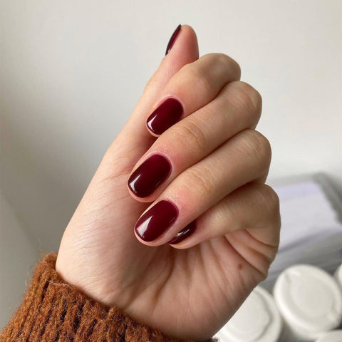 Dark red polish nails