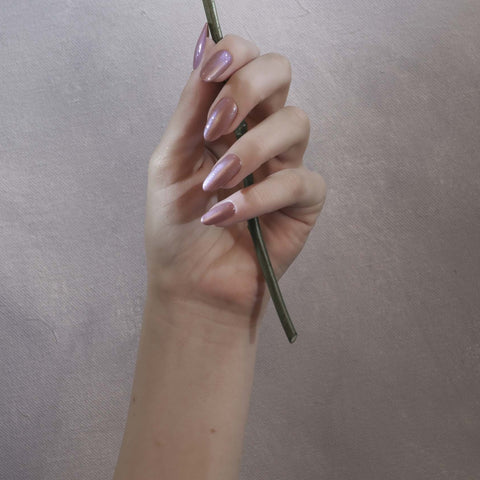 Pearl pink manicure holding white flower